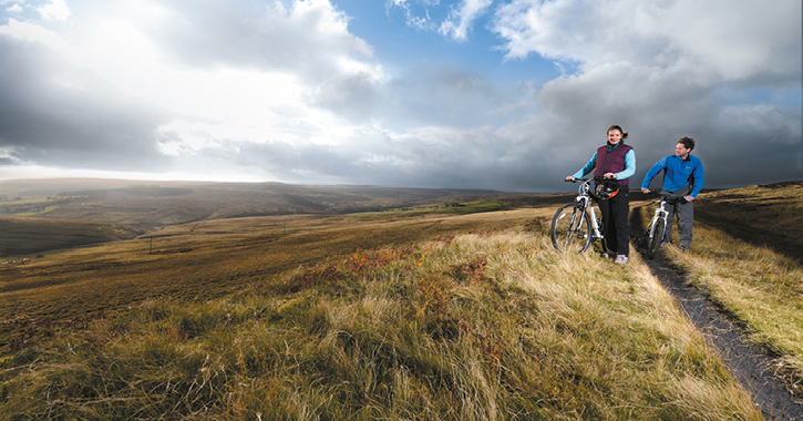 couple riding bikes in Durham Dales